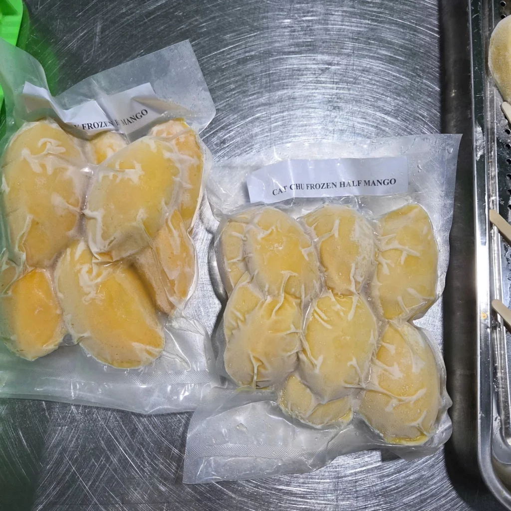 Vacuum-packed Vietnamese frozen mango portions on stainless steel tray – HAVIGO